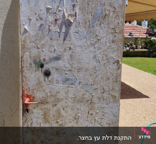 דלת ישנה עם צבע מתקלף וידית מתכת